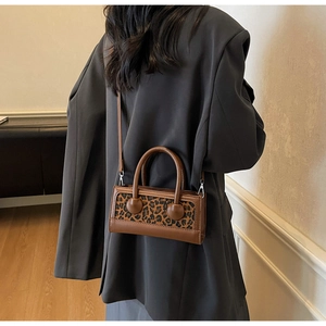 Detail of leopard print patchwork shoulder bag with round handle and detachable strap