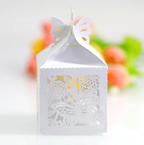 Detailed laser-cut butterfly and floral patterns on white wedding favor candy box