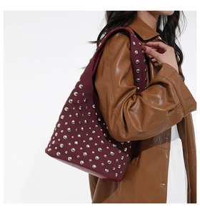 Dettaglio borsa tote bordeaux satinata con borchie argento e tracolla hobo vintage