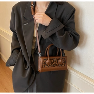 Detail showing leopard print texture and brown faux leather finish on this stylish square bag
