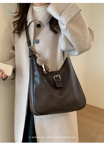 Détail du sac à bandoulière rétro marron foncé avec charme en peluche et sangle