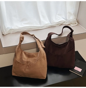 Texture détaillée des sacs fourre-tout en daim camel et café foncé sous lumière naturelle