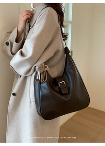 Détail du sac hobo marron vintage avec boucle argentée et breloque en peluche douce