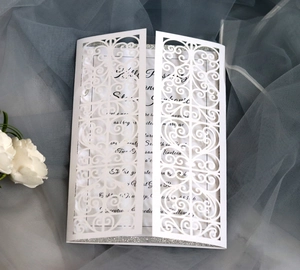 Detail of laser-cut European wedding invitation with silver glitter and elegant floral patterns