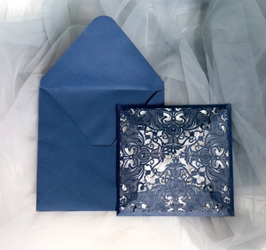 Navy blue laser cut wedding invitation set with elegant floral patterns on a matte envelope