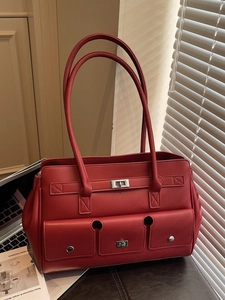 Classic red leather tote bag with three front pockets and metallic twist locks in a retro style