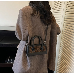 Street style view of a mini leopard print handbag with large round handle bases