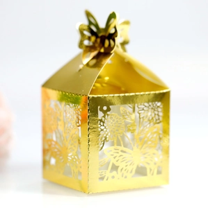 Detail of laser-cut butterfly and floral patterns on golden metallic candy gift box