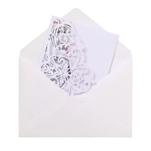 Detail of white laser-cut wedding invitation set featuring floral butterfly patterns