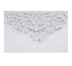 Macro detail of laser-cut floral lace pattern on elegant white pearl paper invitation