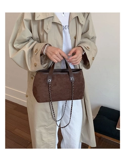 Detail of dark brown suede bucket bag with silver chain and smooth leather handle