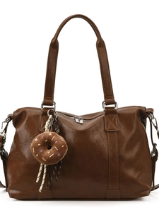 Brown vintage faux leather tote bag with donut plush keychain in a front view shot