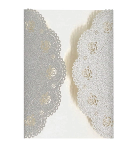Macro view of silver glitter laser-cut wedding invitation featuring rose patterns