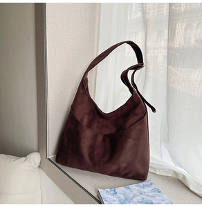 Détail du sac hobo en daim marron foncé avec texture vintage et poche latérale
