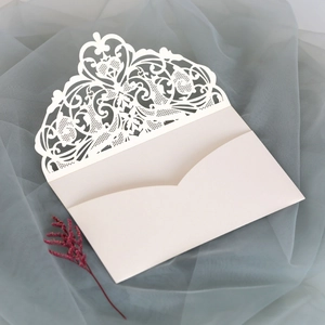 Detailed laser-cut lace pattern on a cream white wedding invitation envelope