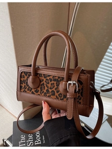 Fashionable leopard print handbag with brown leather trim and detachable shoulder strap