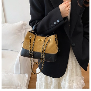 Detailed view of the vintage brown and black bucket bag with a metal chain strap