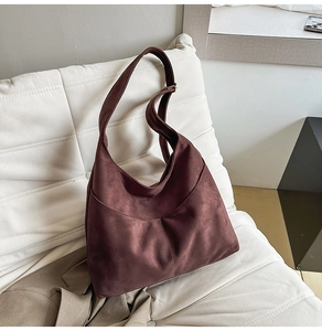 Vue détaillée du tissu en daim rouge vin et de la boucle en métal de ce sac fourre-tout