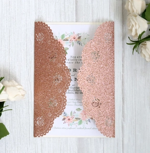 Detail of rose gold glitter laser cut wedding invitation with floral insert card