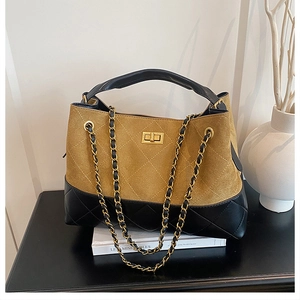 Detail of quilted leather bucket bag with ginger suede contrast and gold turn-lock