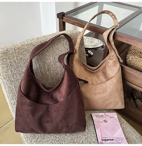 Gros plan de sacs hobo en daim marron foncé et kaki avec des coutures en patchwork