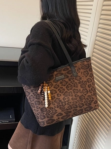 Vintage leopard print tote bag with beaded pendant strap shown on model shoulder