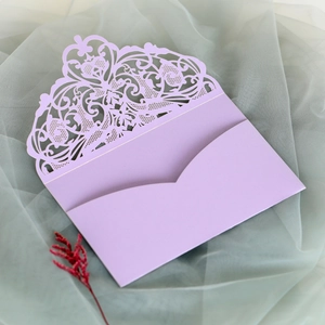 Detail of lavender laser-cut lace wedding invitation with intricate floral patterns