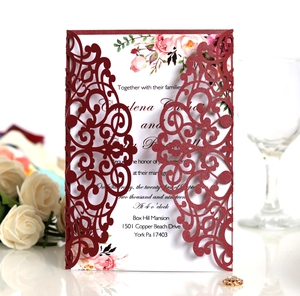 Intricate laser-cut burgundy wedding invitation with elegant floral printed inner card