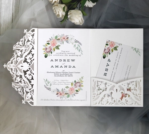Detail of laser cut lace wedding invitation set with white floral card and RSVP note