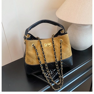 Detail of quilted two-tone shoulder bag with golden twist lock and chain strap