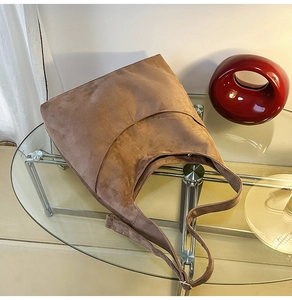 Détail de la couture et texture suédine d'un grand sac cabas vintage marron