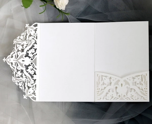 Detailed laser-cut white wedding invitation card with elegant vine and floral hollow patterns