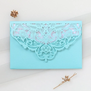 Detail of laser-cut lace invitation card in tiffany blue with shimmering texture
