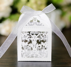 Detail showing laser-cut vine patterns and white silk ribbon on wedding candy box