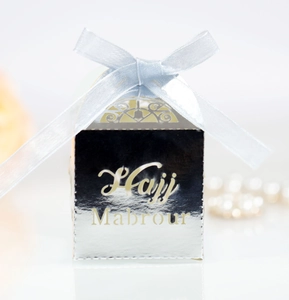 Detail of silver Hajj Mab rour gift box with blue ribbon bow and intricate cutout design
