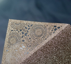 Laser cut champagne gold glitter wedding invitation card with intricate floral pattern