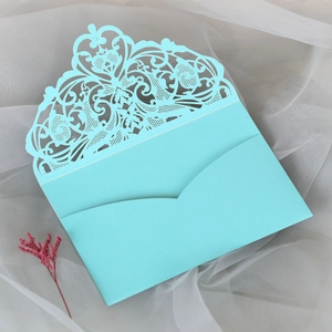 Detail of laser-cut light blue lace wedding invitation envelope with floral patterns