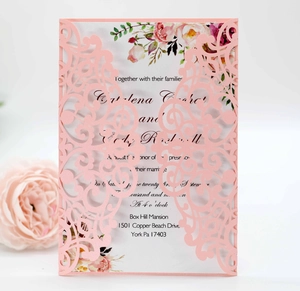 Macro view of laser cut floral hollow design on elegant pink wedding invitation card
