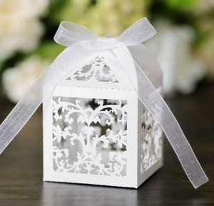 Detail of laser-cut vine pattern on white gift box with elegant organza ribbon bow