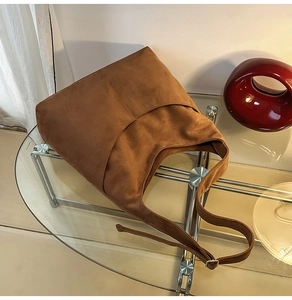 Détail du grand sac cabas en daim marron avec boucle en métal réglable et texture douce