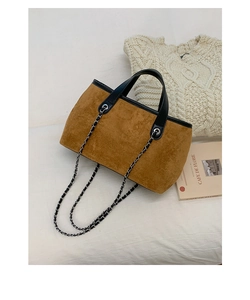 Detailed close-up of brown suede tote bag with chain strap and elegant black handles