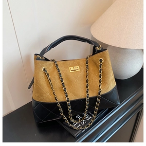 Close-up of contrast color bucket bag with diamond lattice pattern and gold turn-lock