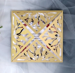 Detailed laser-cut gold lace wedding invitation with elegant floral inner card insert