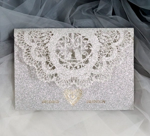 Silver glitter wedding invitation card with laser cut lace edges and heart cutout design