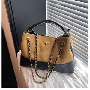 Detail view of large bucket bag with two-tone design, diamond quilting, and gold turn-lock