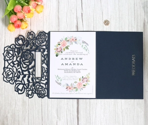 Navy blue laser cut wedding invitation with rose hollow pattern on white wood background