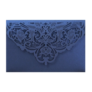 Macro detail of dark blue laser-cut lace pattern on pearlescent wedding invitation