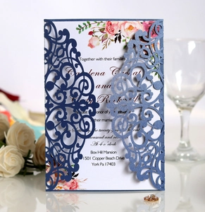 Detail of laser-cut navy blue wedding invitation with floral insert and pearlescent finish