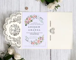 Elegant laser cut cream wedding invitation card with floral inner sheet on wood
