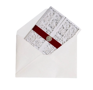Invitation de mariage découpée au laser avec motif creux et ruban rouge élégant
